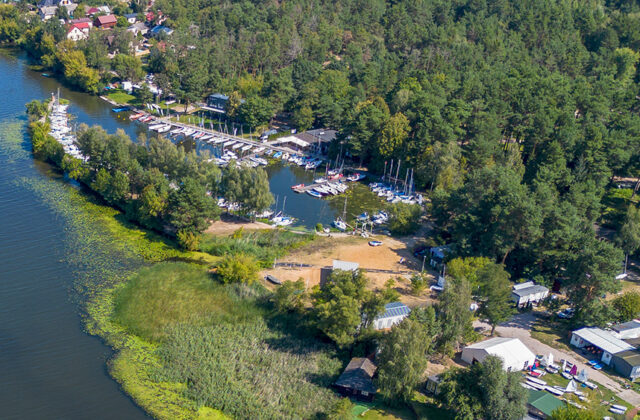 Port „Pilawa” z drona – zatoka z łodziami wśród sosnowego lasu