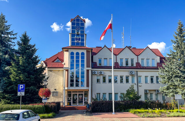 Budynek Urzędu Gminy Nieporęt z przeszkloną klatką schodową i masztem z flagą Polski
