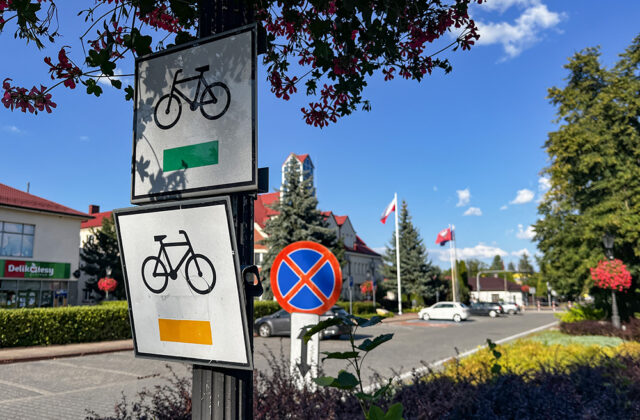 Znaki rowerowe szlaku żółtego i zielonego na słupie w centrum Nieporętu