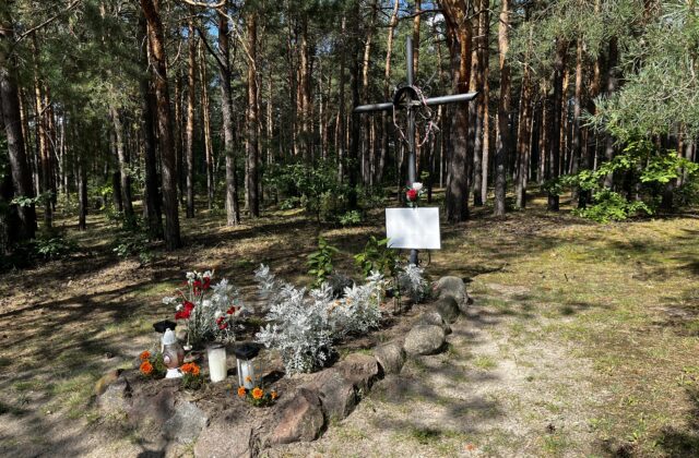 Mogiła w Nowolipiu obłożona kamieniami, z kwiatami, zniczami i metalowym krzyżem