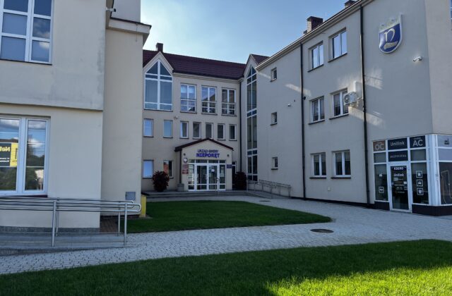 Dziedziniec Urzędu Gminy Nieporęt z jasnymi budynkami i trawnikiem