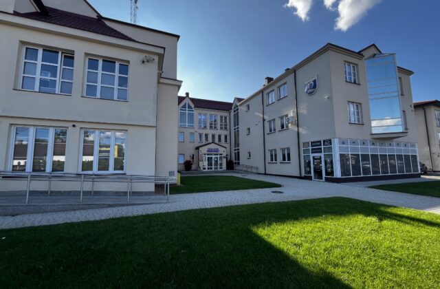 Jasne skrzydła budynku Urzędu Gminy Nieporęt wokół trawiastego dziedzińca