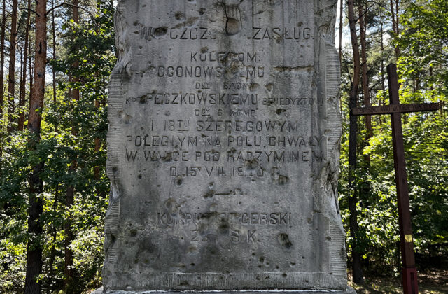 Inskrypcja na pomniku Strzelców Kaniowskich, w tle drewniane krzyże
